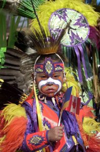 Ein Junge der Cree, die zu den größten indigenen Gruppen in Nordamerika zählen, in festlicher traditioneller Kleidung.