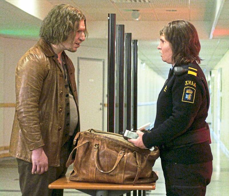 Mann und Frau in Uniform schauen sich über einer Tasche in die Augen