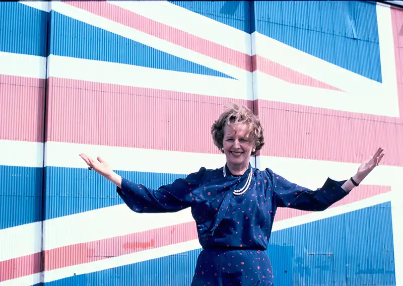 Margaret Thatcher steht vor britischer Flagge