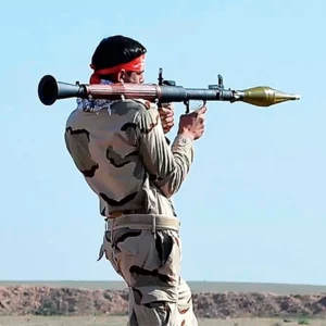 Ein Soldat in Uniform mit Schusswaffe auf der Schulter.