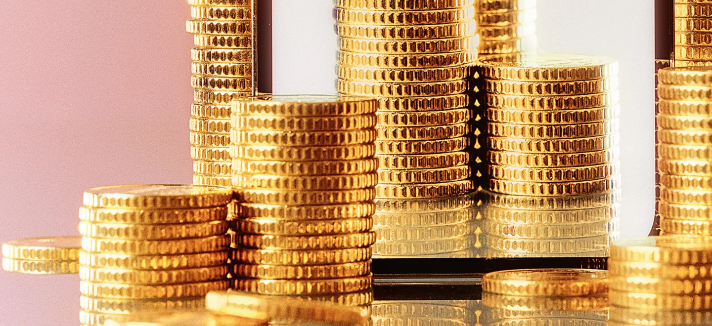 Illustration zeigt ein Smartphone, davor aufgetürmte Geldmünzen.