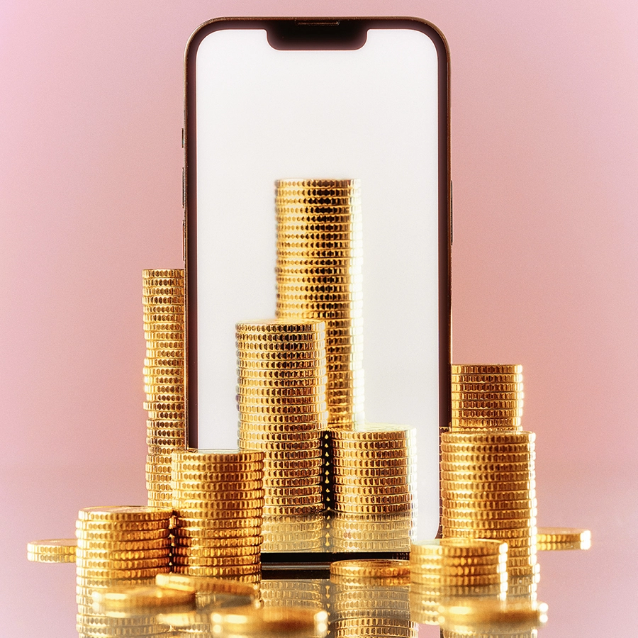 Illustration zeigt ein Smartphone, davor aufgetürmte Geldmünzen.