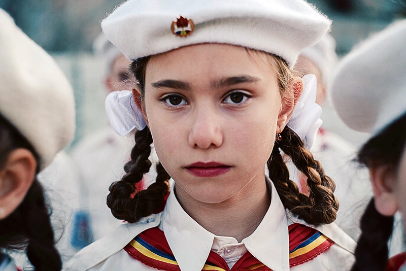 Mädchen mit Zöpfen und weißer Mütze.