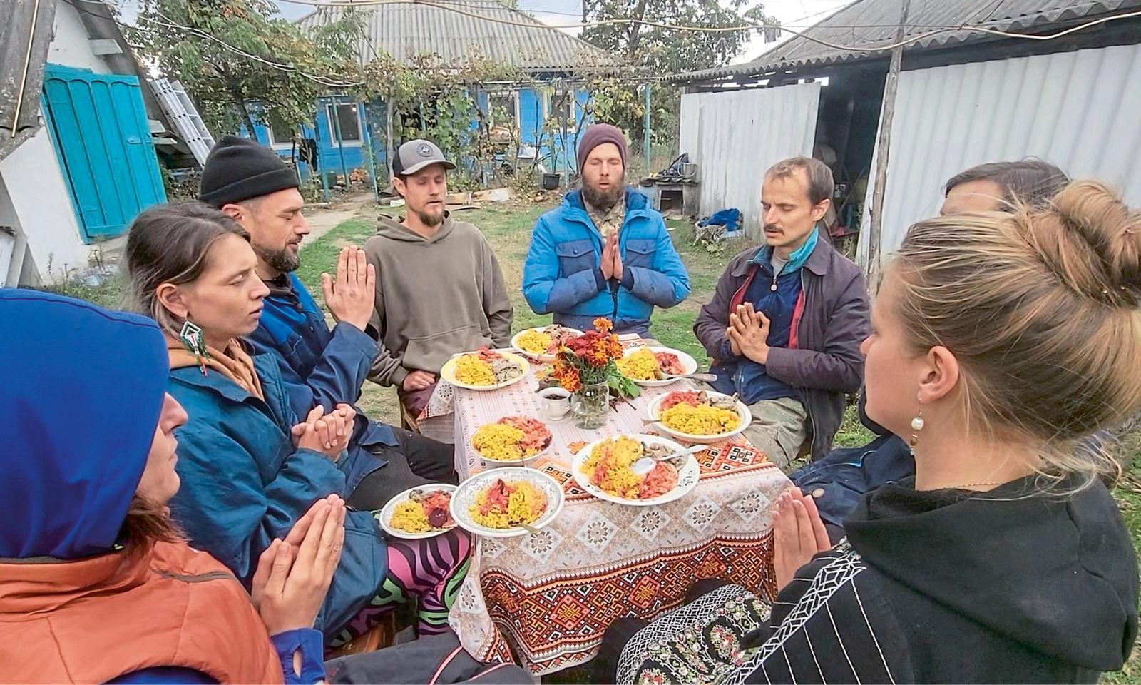 Menschen sitzen um einen Tisch herum im Freien.