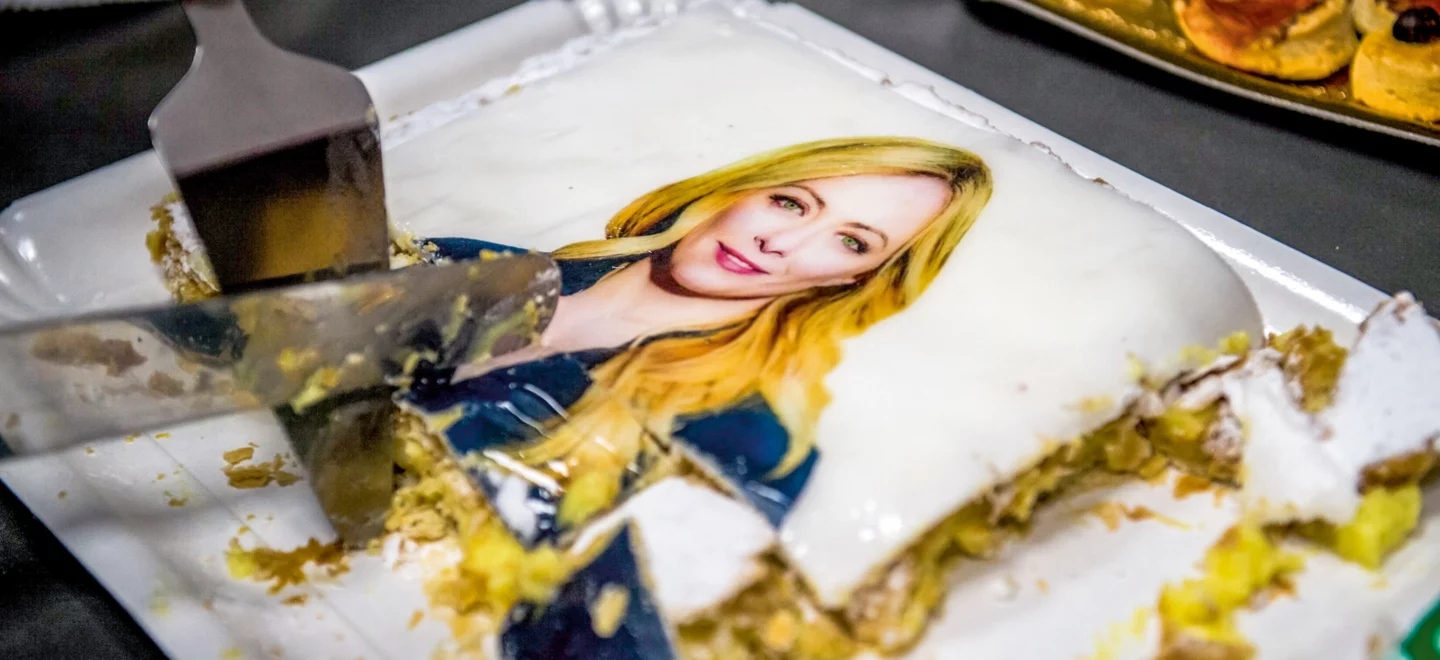 Eine Torte mit Giorgia Meloni als Aufdruck wird angeschnitten