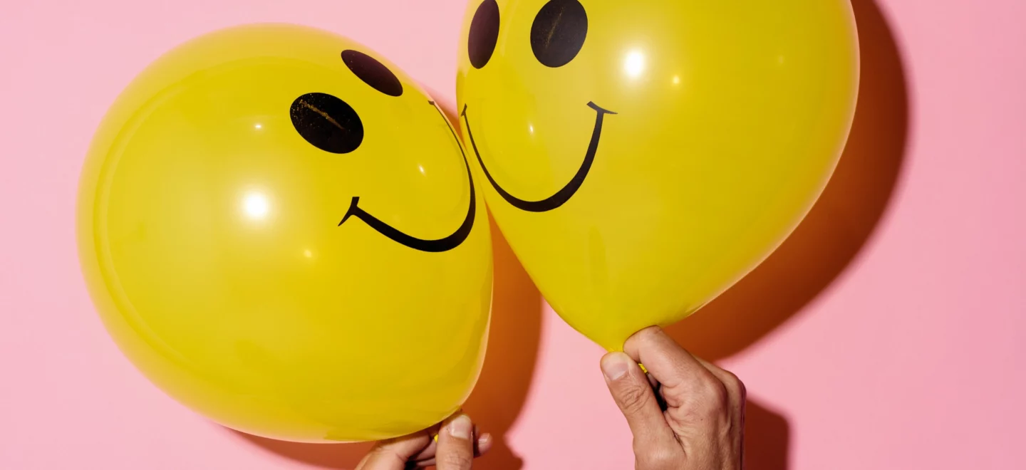 Zwei gelbe Ballons mit Smileys
