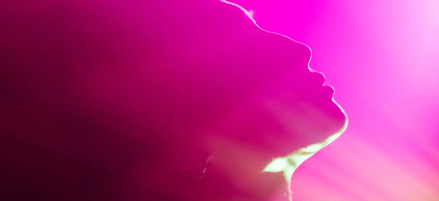 Bild eines Menschen, der nach oben schaut, mit lila Beleuchtung