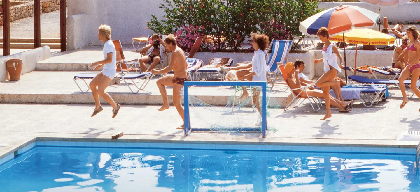 Urlauber machen Morgengymnastik an einem Pool.