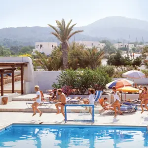 Urlauber machen Morgengymnastik an einem Pool.