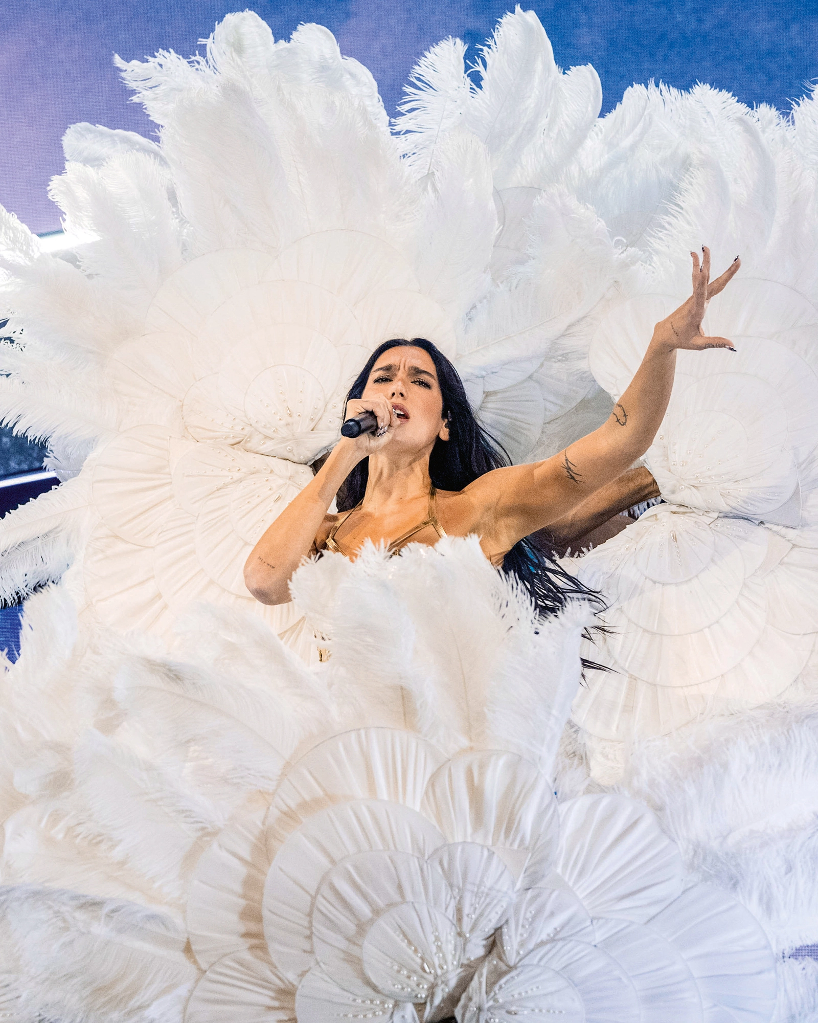 Dua Lipa singt in weißem Federkostüm