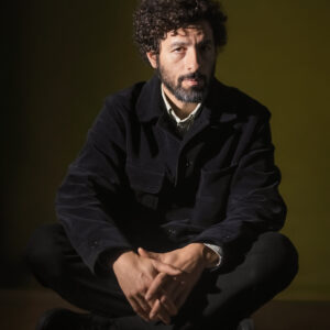 José González Porträt im Schneidersitz