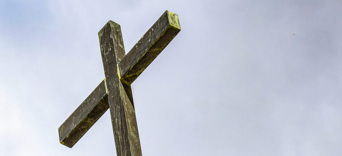 Ein Holzkreuz ragt in den Himmel.