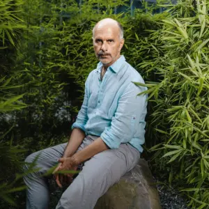 Der Schauspieler Christoph Maria Herbst vor grüner Hecke.